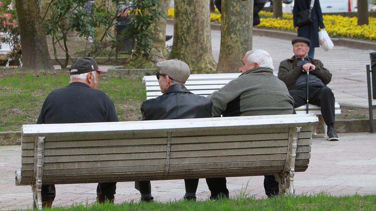 Un grupo de jubilados departen en un banco de la ciudad de Ourense