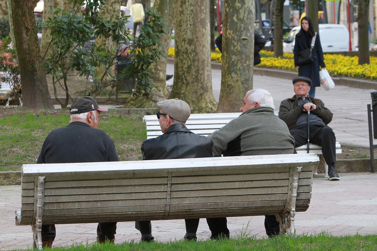 Un grupo de jubilados departen en un banco de la ciudad de Ourense.