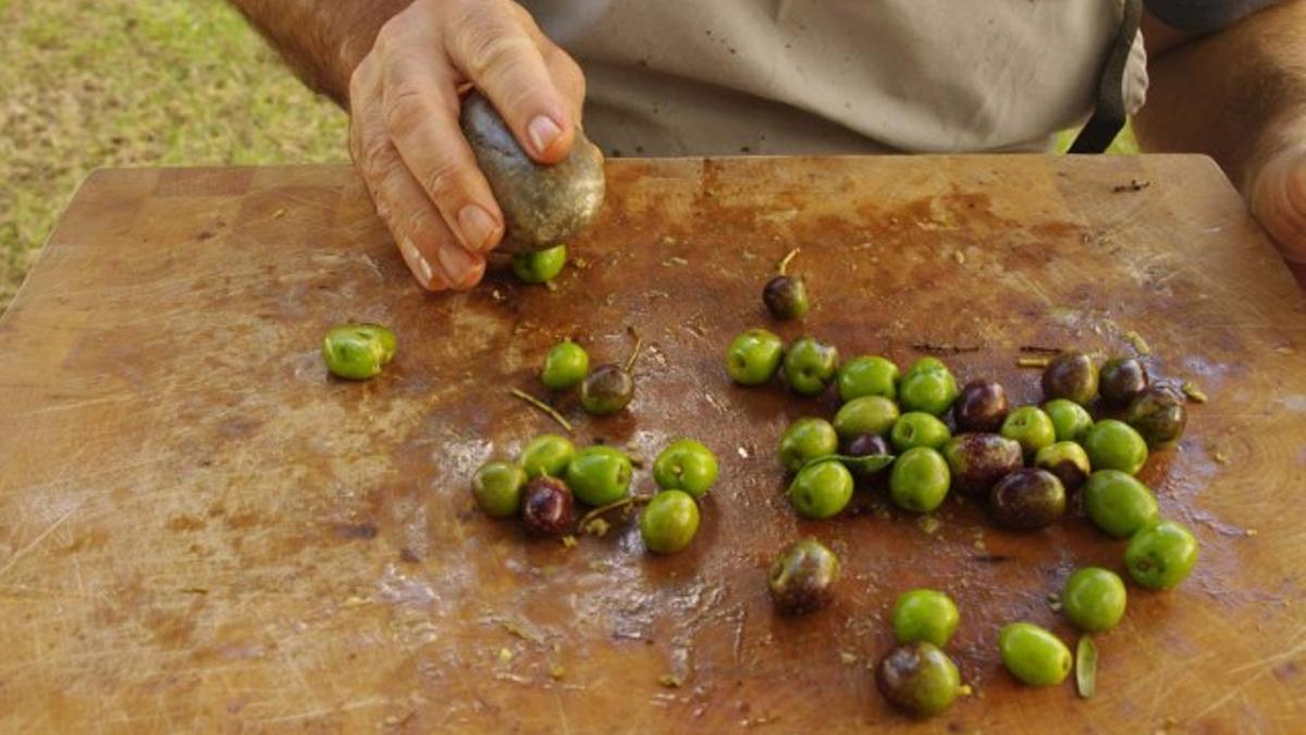 Un hombre parte olivas
