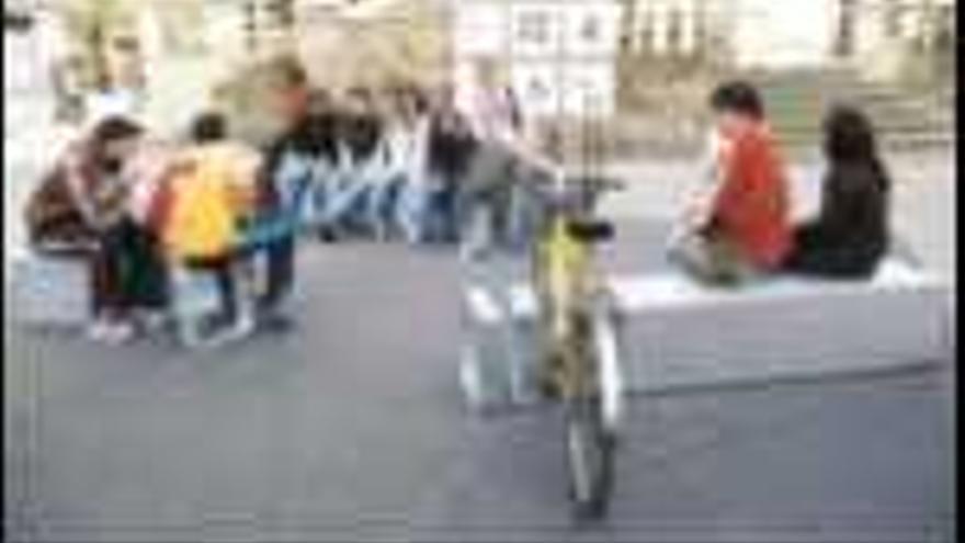 Varios adolescentes prueban el nuevo mobiliario, que incluirá pequeños aparcamientos de bicicletas. / rafa vázquez