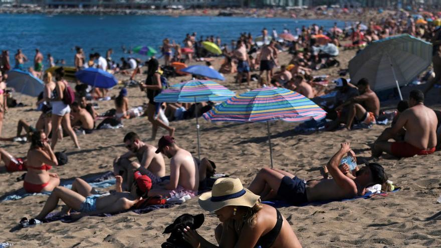 Los bañistas disfrutan en una playa de Barcelona.