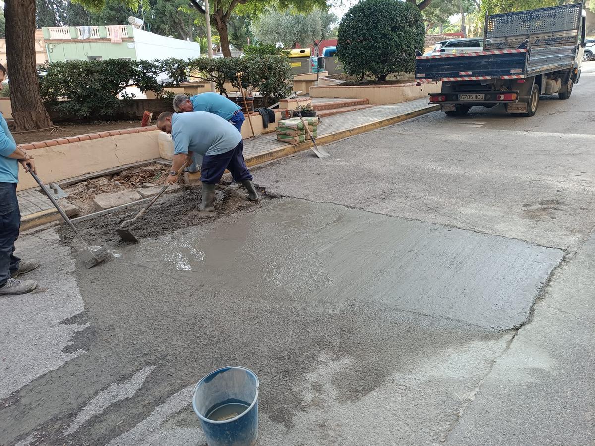 Varios operarios asfaltan las calles de Moncada.