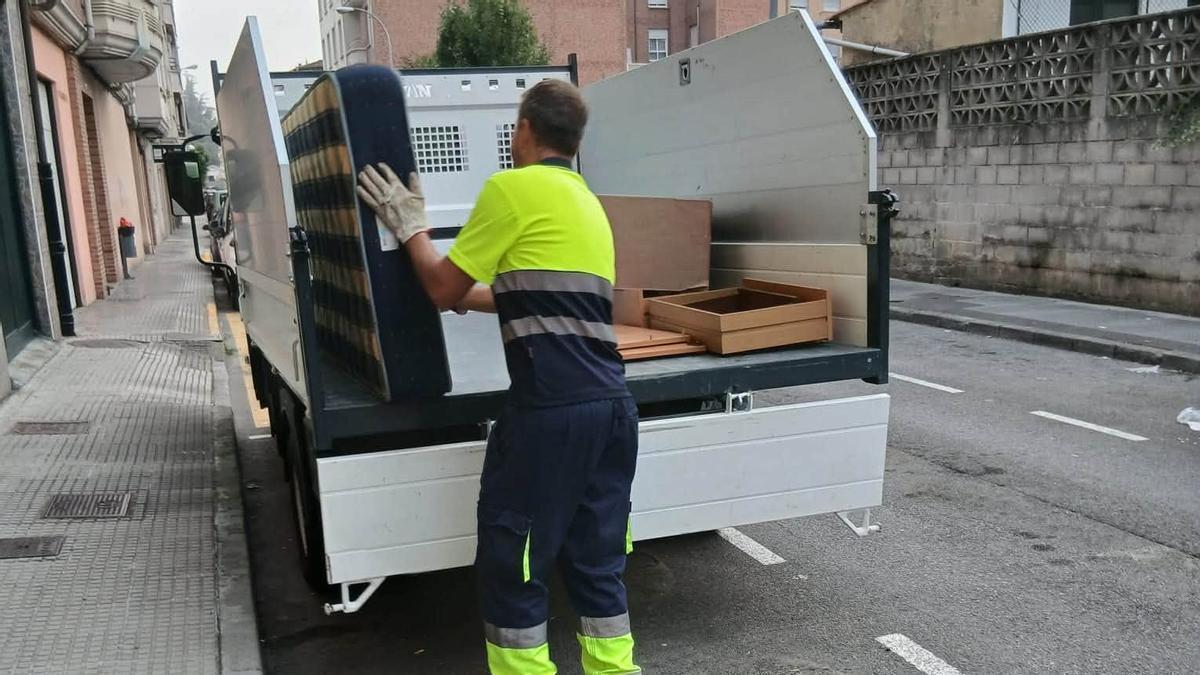 Un operario, en el servicio de recogida de enseres "puerta a puerta" en Laviana.