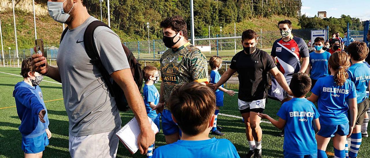 Los integrantes de la Escuela ayer con los jugadores del primer equipo. | Mara Villamuza