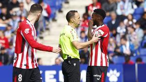Iñaki Williams le comunica a Cuadra Fernández, el colegiado del Espanyol-Athletic, que ha recibido insultos racistas de un sector del RCDE Stadium.