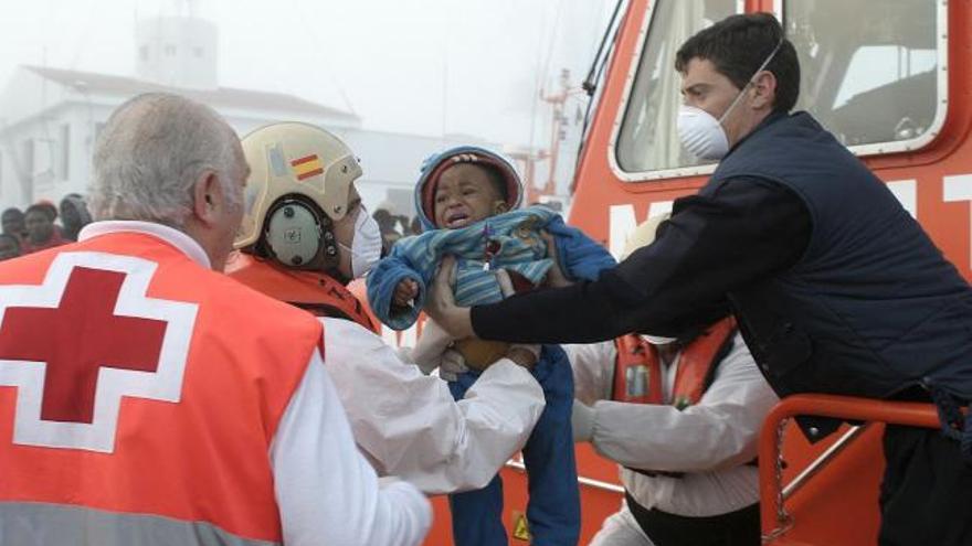 Técnicos de los servicios de Emergencias trasladan a uno de los niños encontrados en una patera, frente al las costas de Granada, en la que viajaban 73 inmigrantes de origen subsahariano, entre ellos varios niños y 18 mujeres. La Guardia Civil y Salvamento Marítimo localizó la embarcación cuando se encontraba a unas 18 millas al sur de la costa de Motril, localidad hasta donde después fueron remolcados.