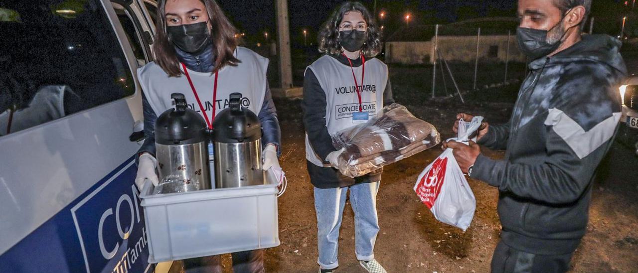 Reparto de comida caliente y material contra el frío a las personas que duermen en la calle y el trabajo previo de preparación que se hace en la sede de Conciénciate. | ANTONIO AMORÓS