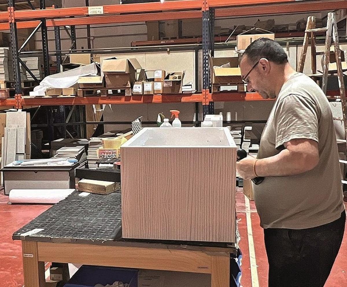 Un empleado de una fábrica de muebles de Lucena termina un pedido realizado.