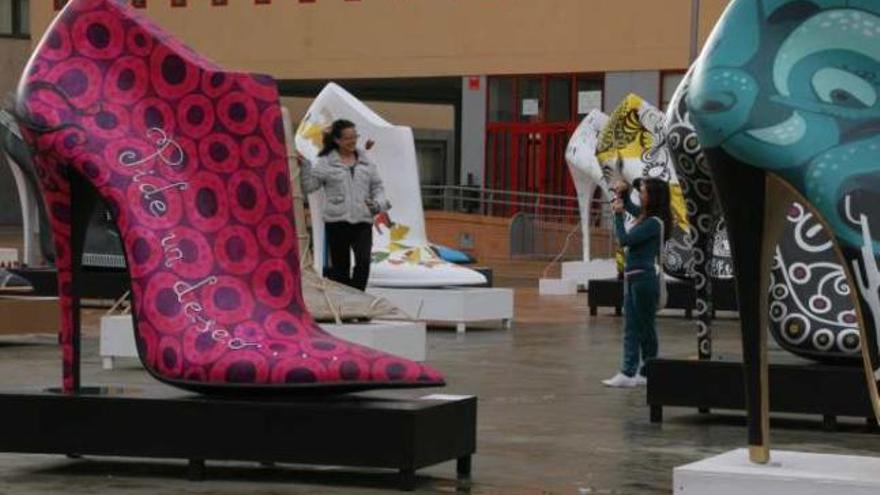 Una persona se fotografía con uno de los zapatos gigantes de la exposición de Inescop.