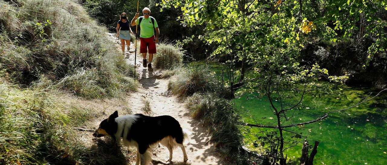 Unos paseantes a la orilla del río Dobra.