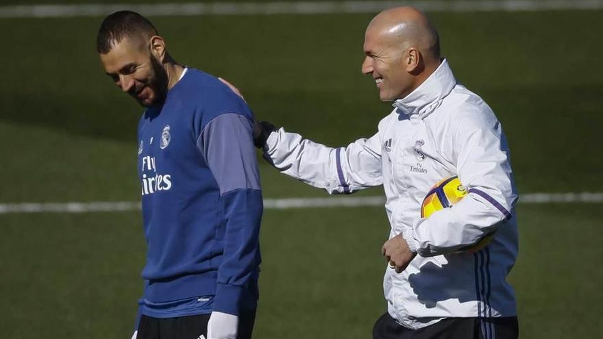 Zidane bromea con Benzema durante el entrenamiento de ayer en Valdebebas. emilio naranjo / efe