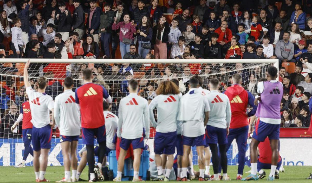Los jugadores lanzaron balones a la grada y, a la derecha, tres niños piden las camisetas a varios futbolistas. | K . FÖRSTERLING (EFE) / F. CALABUIG