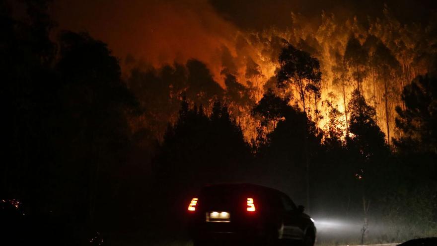 Un vehículo pasa junto a uno de los focos del incendio de Trabada, en Lugo. |   // CARLOS CASTRO