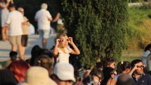Una niña observa el eclipse solar con gafas homologadas