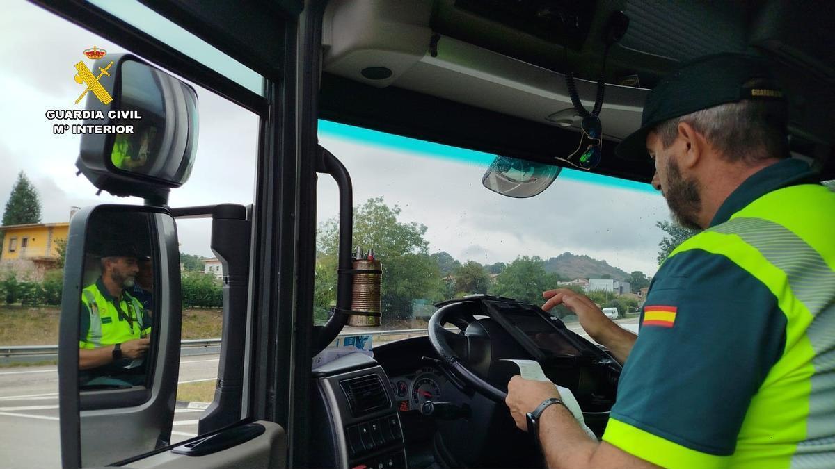 Un agente de Tráfico inspecciona el tacógrafo del camión.