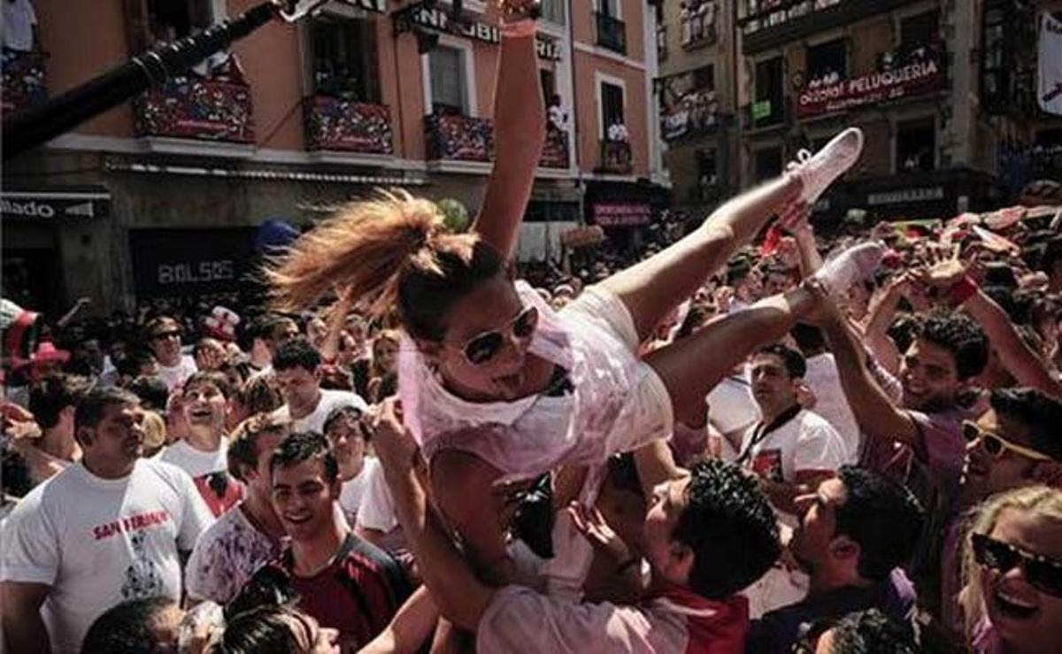 Una noia es llança als braços de les desenes de persones concentrades a la plaça de l’Ajuntament pamplonès.