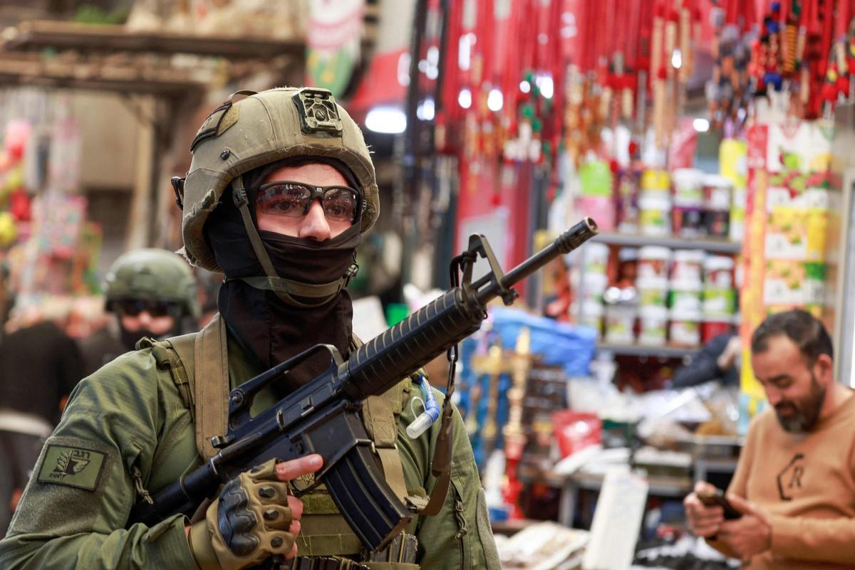 Un soldado israelí patrulla los puestos del mercado en la Ciudad Vieja de Nablus, en la Cisjordania palestina, territorio ocupado por Israel, el 12 de abril de 2026.
