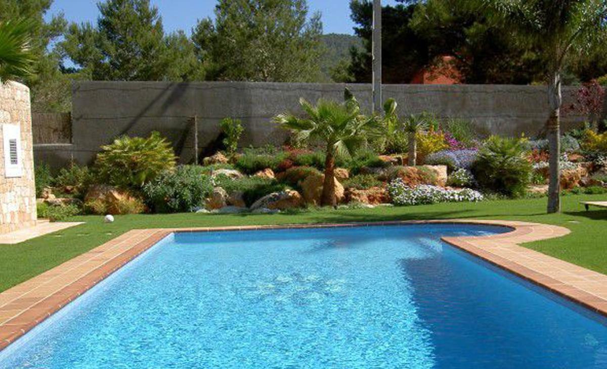 Vegetación mediterránea que decora una piscina en una casa payesa.