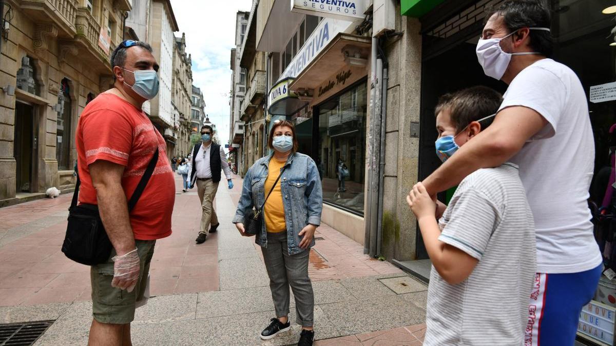 Un grupo charla en la calle en Pontevedra manteniendo la distancia y con mascarillas. // G. Santos