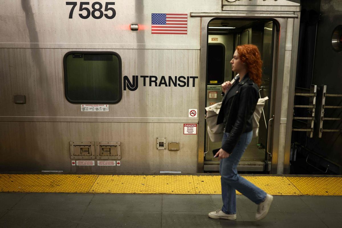 A person walks on the platform next to a NJ Transit train at New York Penn Station in New York City on April 17, 2026. Football fans have expressed outrage at the exorbitant price of transit fares to get to World Cup matches, following reports that US transport authorities have jacked up prices just for this summer's tournament. New Jersey Transit is planning to charge fans more than $100 for tickets from Penn Station in Manhattan to MetLife Stadium in New Jersey during the World Cup, according to a report in The Athletic. A return ticket for the journey normally costs $12.90. (Photo by CHARLY TRIBALLEAU / AFP)