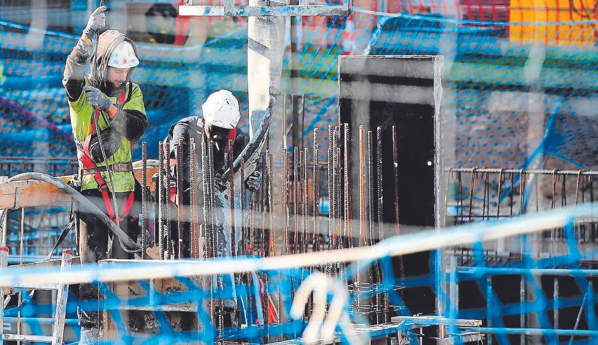 Albañiles trabajando en la estructura de viviendas de nueva construcción.