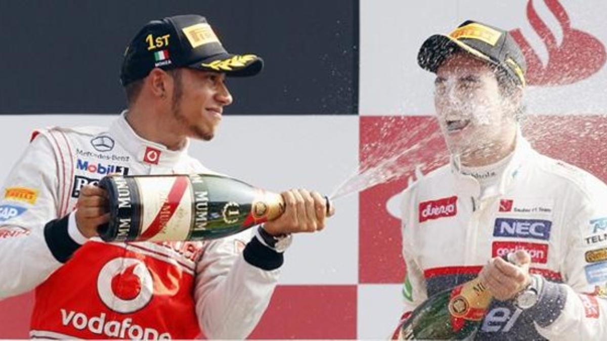 Hamilton riega con champán a Sergio Pérez en el podio del Gran Premio de Italia.