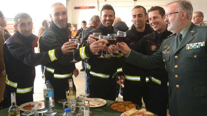 Un grupo de bomberos brinda con un responsable de la Guardia Civil durante el acto de ayer. // R.V.