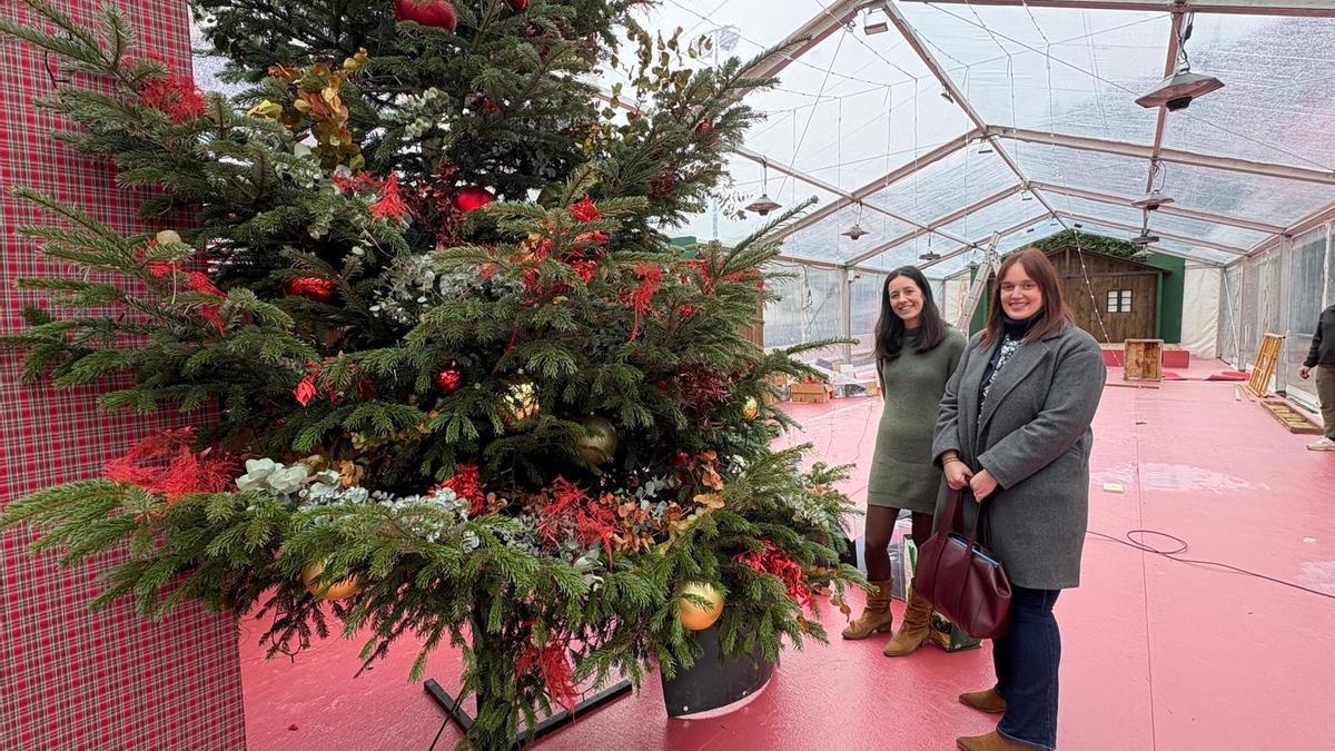 La coordinadora del área de Cultura, Noelia Rodríguez, y la concejala, Tania Rodríguez, en la carpa navideña de la plaza La Oliva.