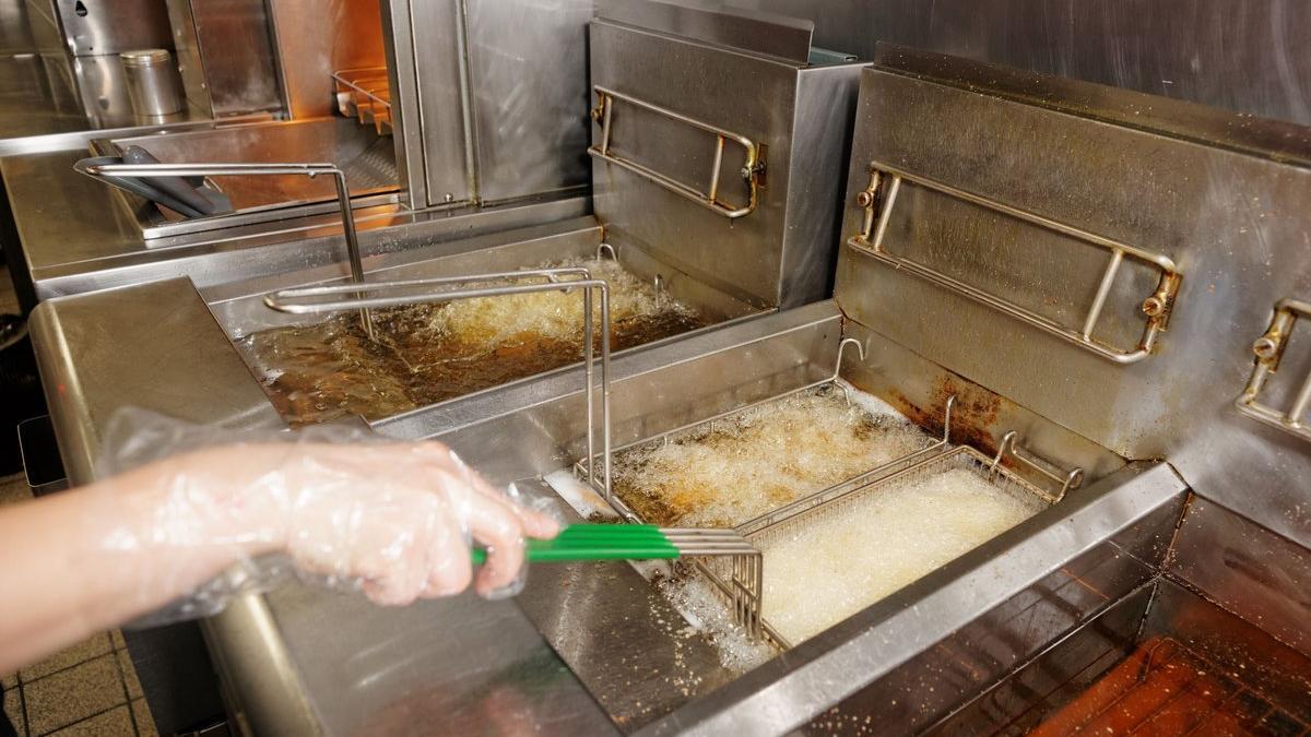 Freidoras con patatas fritas en un restaurante de comida rápida.