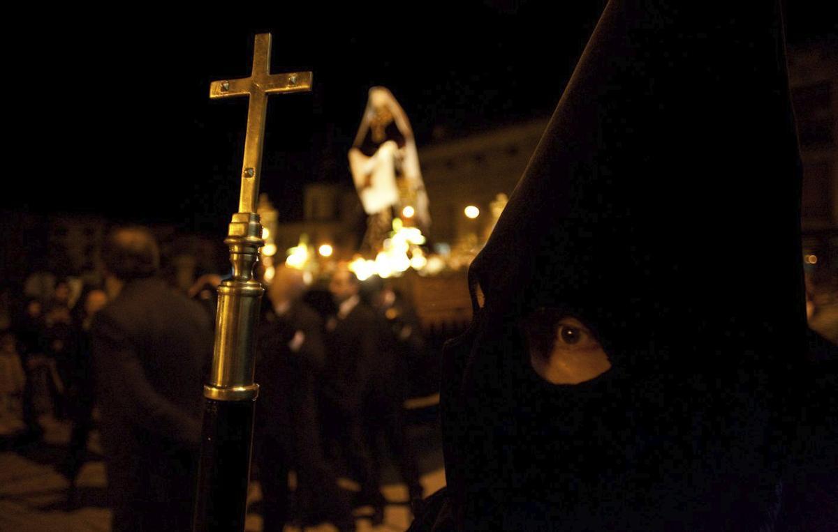 Un cofrade  durante la Procesión de las Tinieblas, con La Verónica detrás. | L. O. Z.
