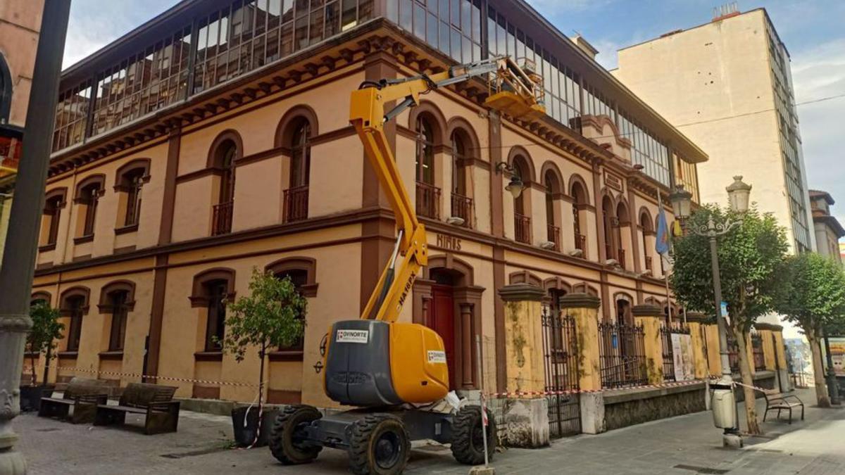 Una grúa arregla el alero de la Casa de Cultura de Sama. | D. O.