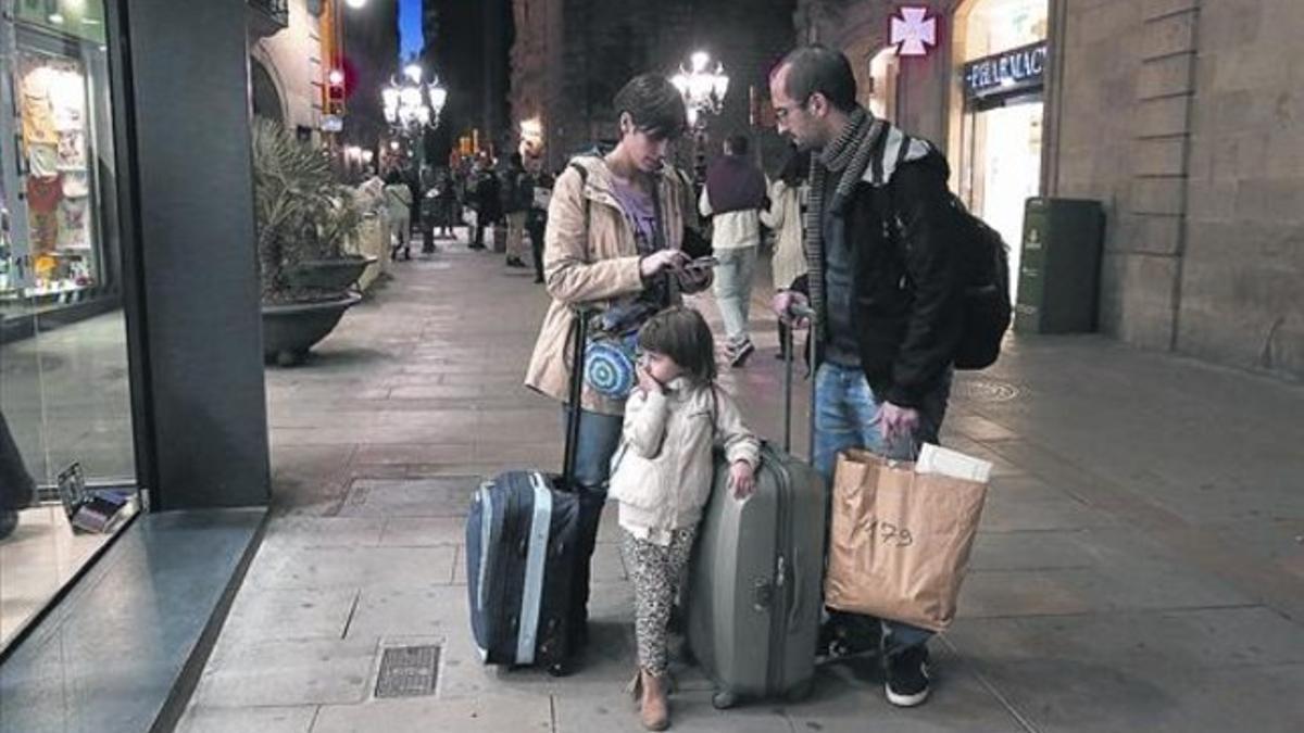 Una familia busca el piso turístico que ha contratado en Ciutat Vella.