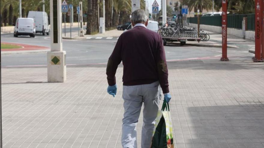 Un vecino de Elche por la calle con una bolsa de la compra