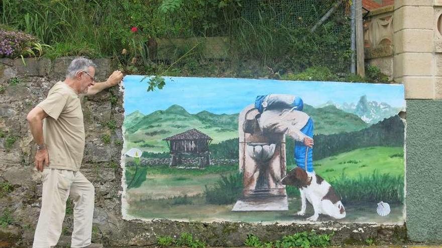 Carlos Jiménez, junto al dibujo que ha realizado en el muro de su casa, en Vega.