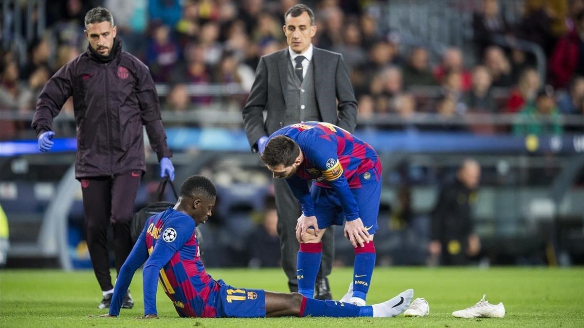 Messi intenta consolar a Dembélé tras su lesión ante el Dortmund.