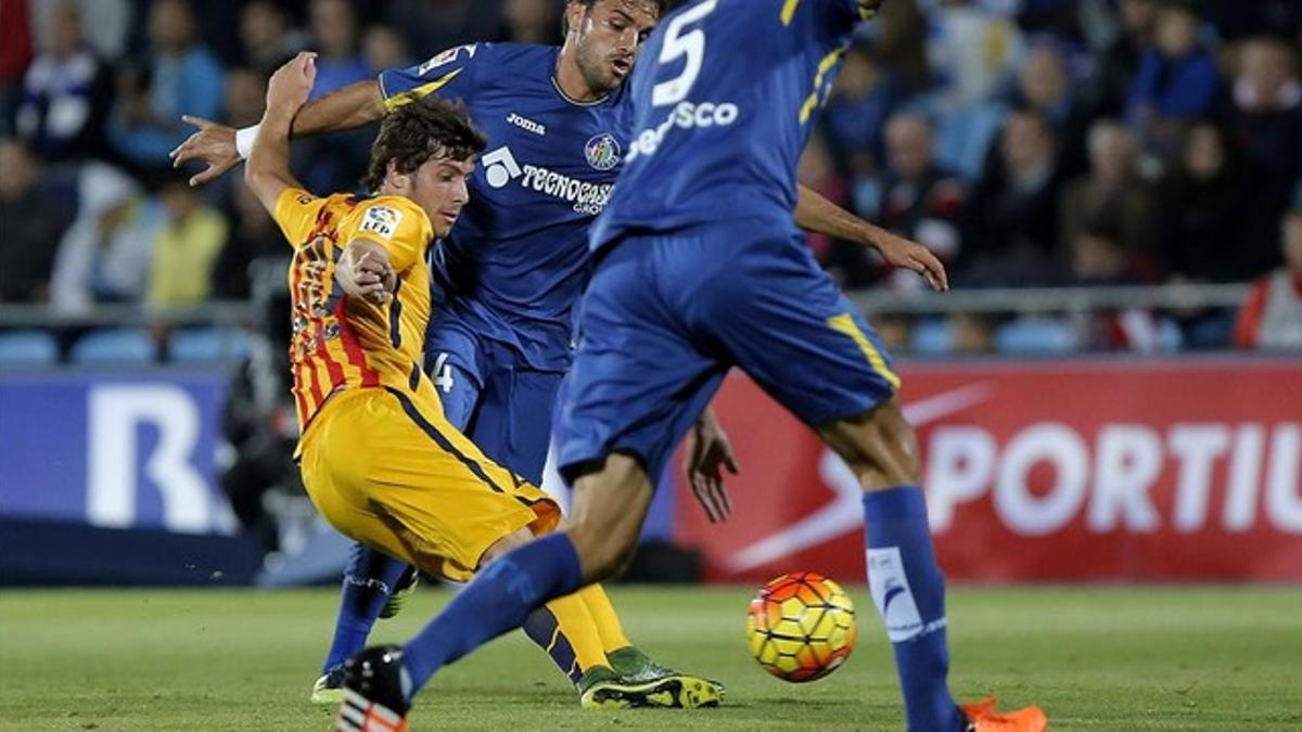 Sergi Roberto da un pase entre dos futbolistas del Getafe.
