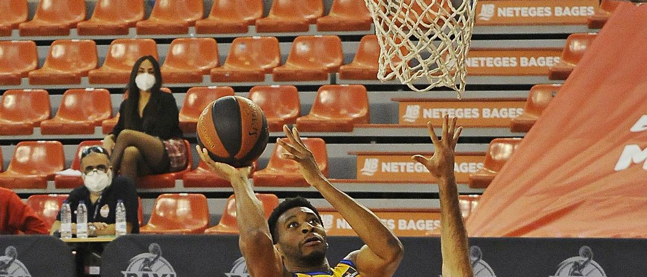 Stan Okoye, alero del Herbalife Gran Canaria, lanza a canasta frente a Vaulet, del Manresa.