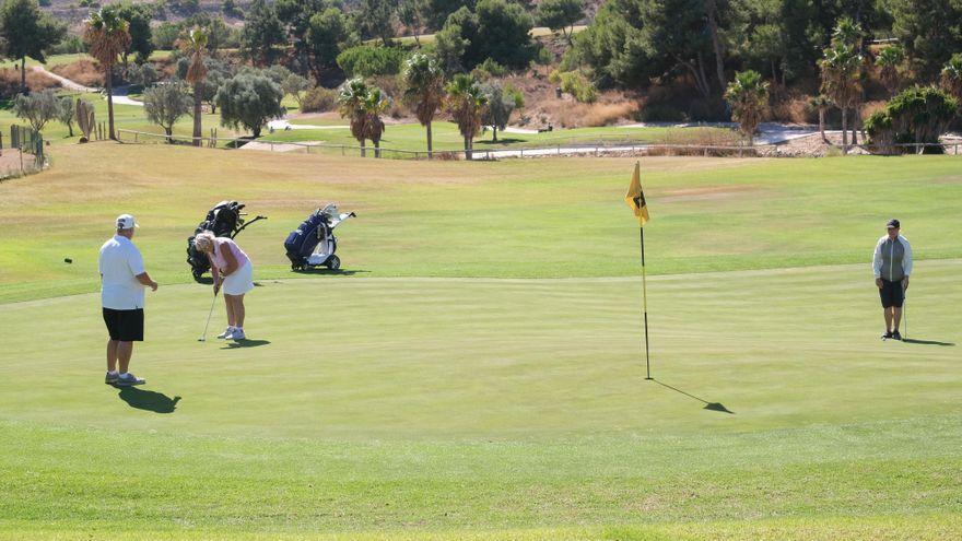 Aficionados al golf jugando en un campo de la provincia