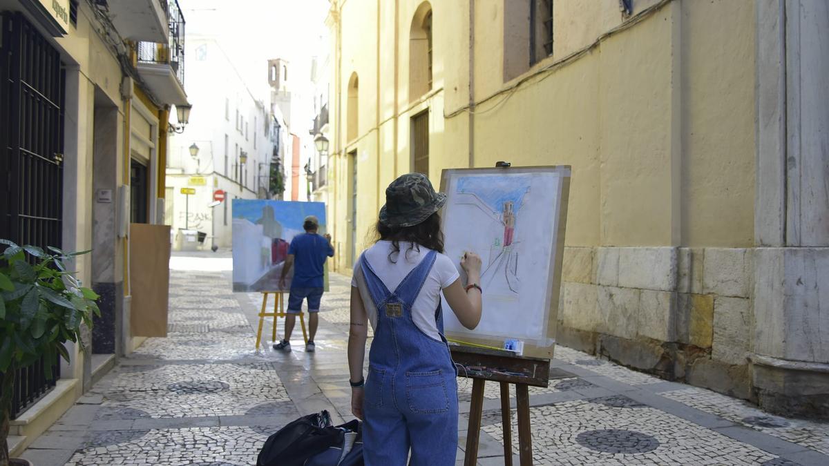Dos artistas pintan la Torre de Espantaperros desde la calle San Juan.