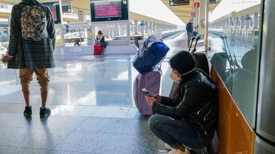 Una joven espera con mascarilla en una estación italiana