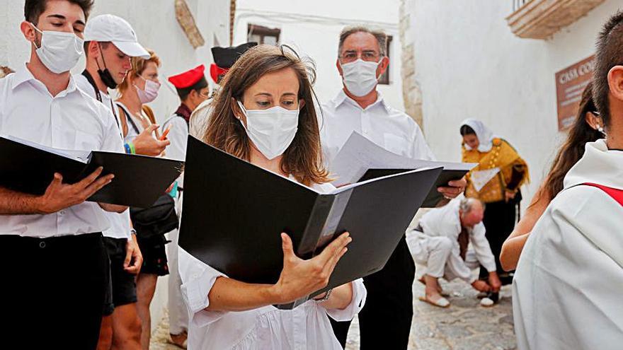 El coro Amics de la Música, frente a la capilla de Sant Ciriac y, al fondo, una payesa abrochándose la ‘espardenya’. 