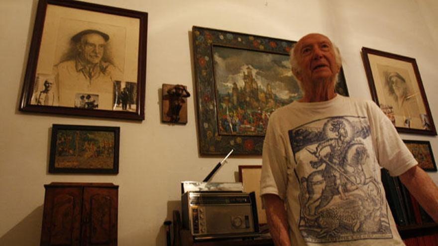 Pío Caro Baroja, delante de un retrato de su tío Pío Baroja y de un cuadro de su hermano Julio.