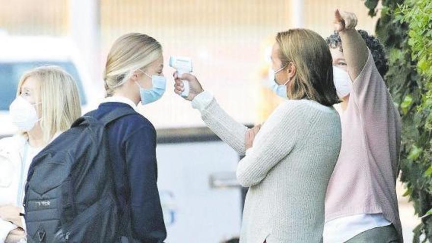 Una maestra toma la temperatura a la princesa Leonor, ayer, a la llegada de esta al colegio.