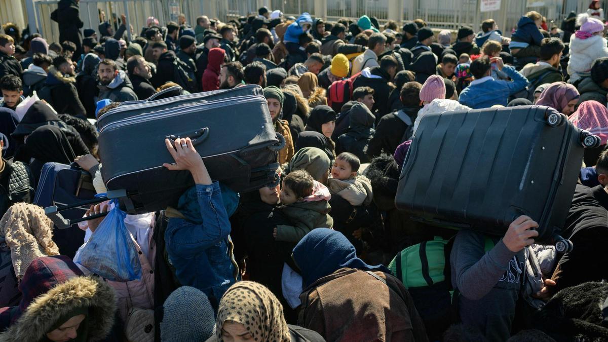 Los residentes sirios de la ciudad de Hatay esperan para cruzar la frontera entre Turquía y Siria después de que se vieron afectados por el terremoto de magnitud 7,8 que asoló la región hace casi dos semanas, en la puerta fronteriza de Cilvegozu