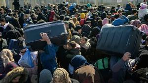 Los residentes sirios de la ciudad de Hatay esperan para cruzar la frontera entre Turquía y Siria después de que se vieron afectados por el terremoto de magnitud 7,8 que asoló la región hace casi dos semanas, en la puerta fronteriza de Cilvegozu