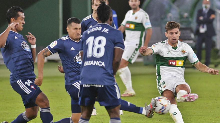 El delantero franjiverde Lucas Boyé remata a puerta con la izquierda rodeado de defensores del Celta de Vigo anoche en el Martínez Valero.