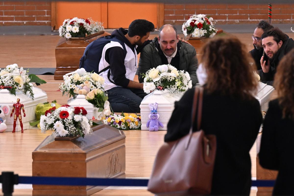 Familiares junto a los ataúdes de las 65 víctimas de un devastador naufragio de inmigrantes frente a la costa sur de Italia