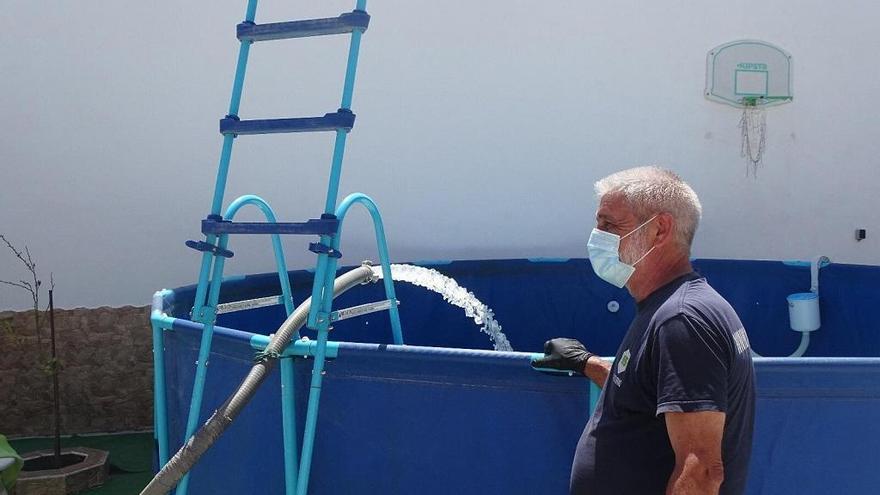 Operario del Ayuntamiento campillero durante el llenado de una piscina.