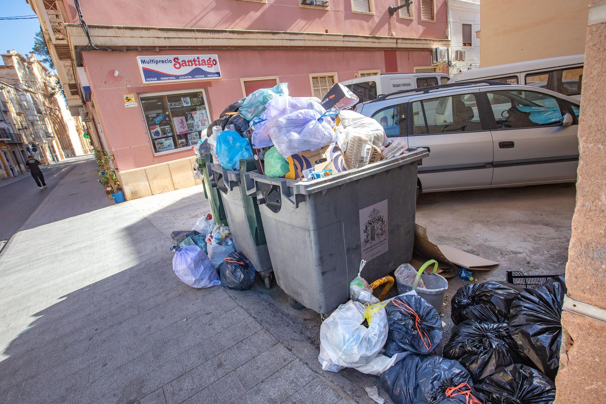 Contenedores abarrotados de basura tras la suspensión del servicio de recogida en Orihuela