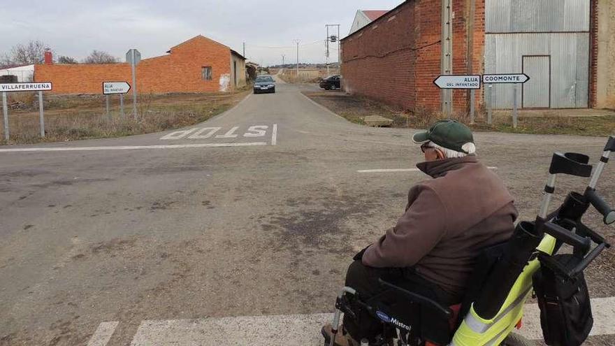 Un vecino de Coomonte, ayer, cruza por el camino que enlaza con Alija del Infantado (León).